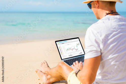 Man trading cryptocurrencies on the beach.
