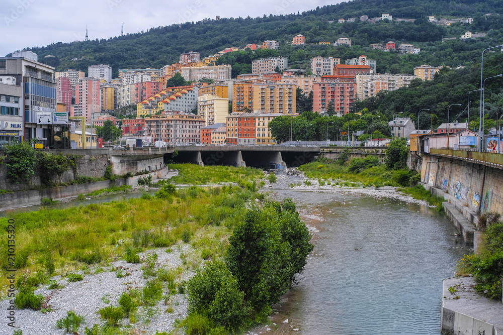 Obraz premium Genoa, Italy - June, 12, 2018: residential district of Genoa on an embankment of river, Italy