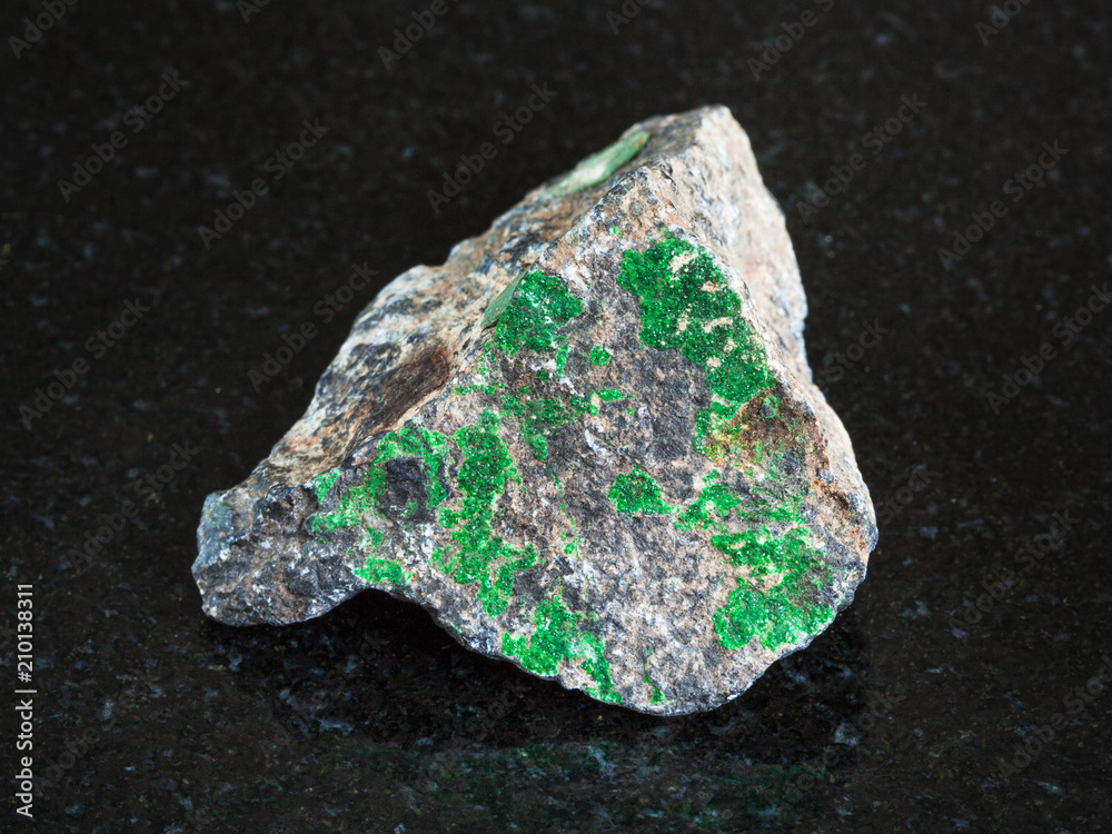 Uvarovite on rough Chromite stone on black