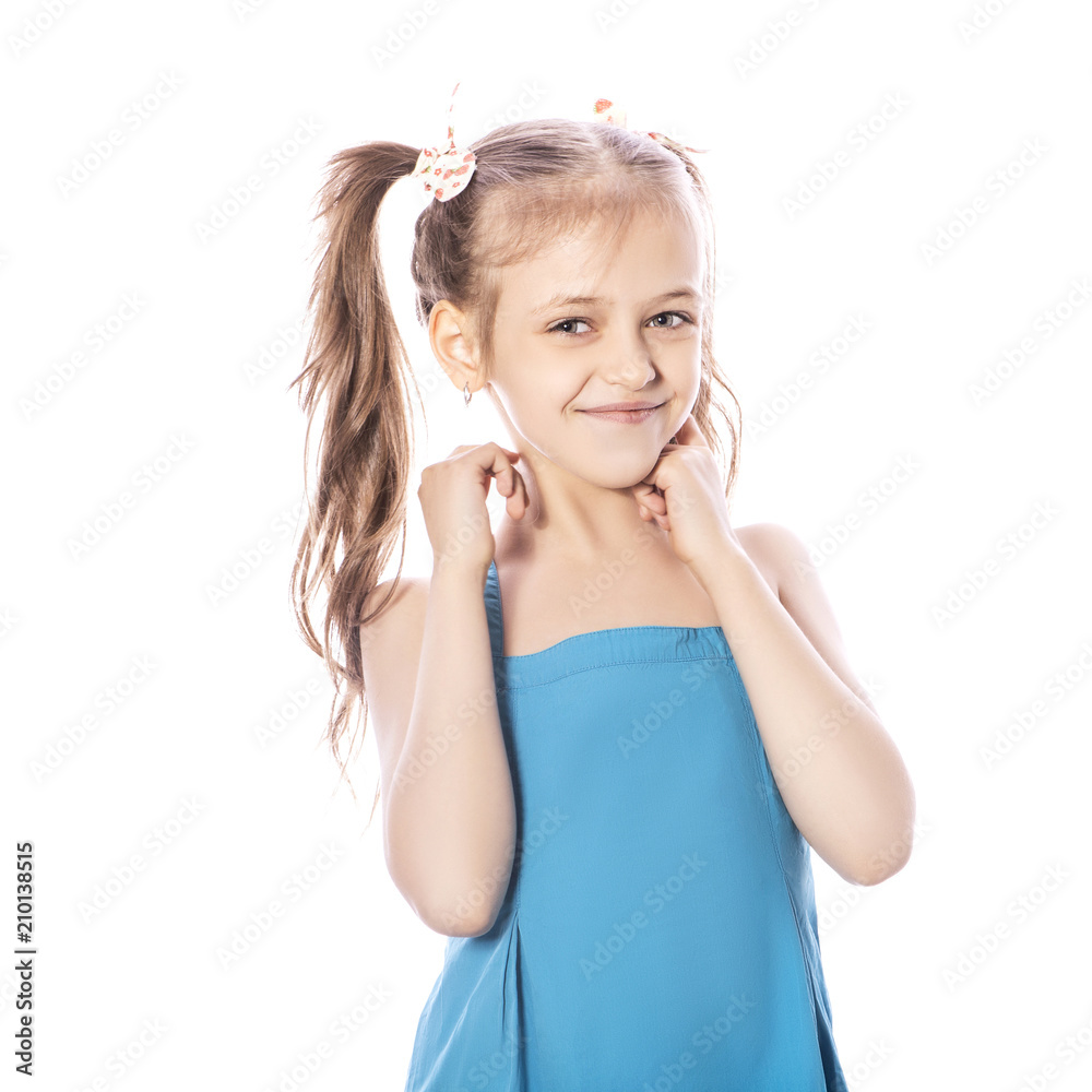 Young seven years old brunette girl in blue dress on a white isolated background. Smile and happiness emotions on her face. Girl miss two front teeth Young seven years old brunette girl in blue dress on a white isolated background. Smile and happiness emotions on her face. Girl miss two front teeth