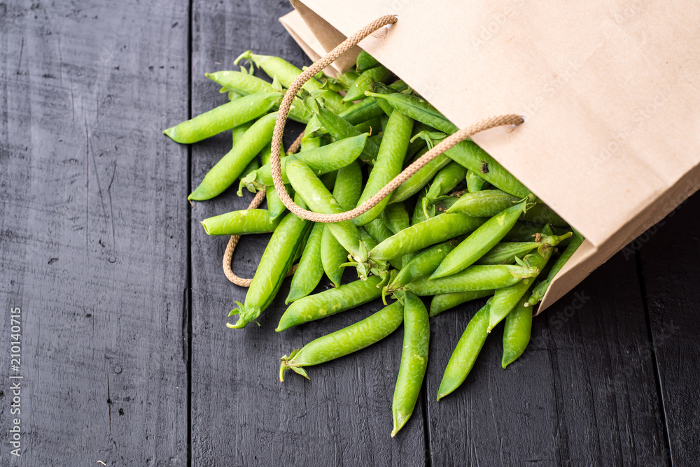 Many pods of peas scattered from paper bag Many pods of peas scattered from paper bag