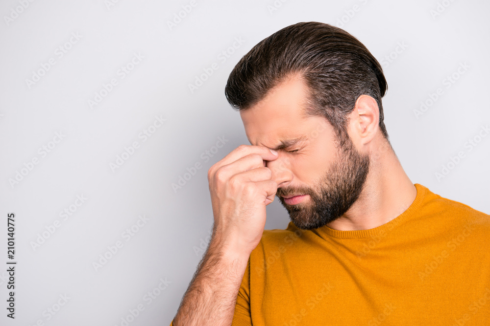 Close up portrait of stressed sick sad upset bearded guy with stylish haircut touching nose-bridge isolated on gray background copy-space Close up portrait of stressed sick sad upset bearded guy with stylish haircut touching nose-bridge isolated on gray background copy-space