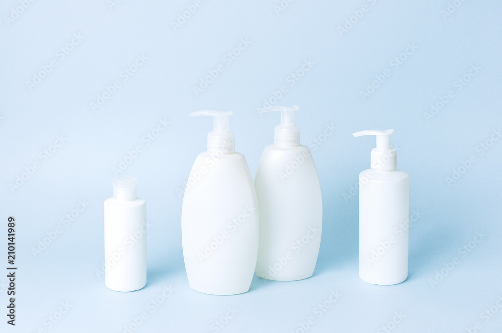 Cosmetic bottle containers on a blue minimalistic background flat lay. Blank label for branding mock-up. Natural beauty product concept. Cosmetic bottle containers on a blue minimalistic background flat lay. Blank label for branding mock-up. Natural beauty product concept.