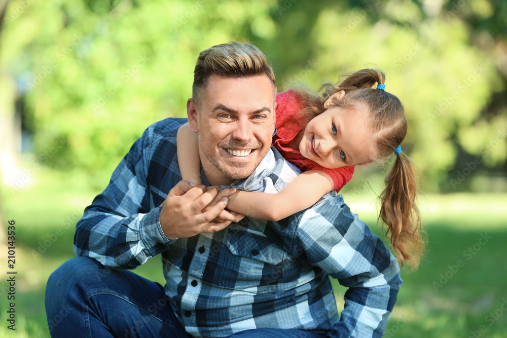 Obraz premium Happy father and daughter in green park
