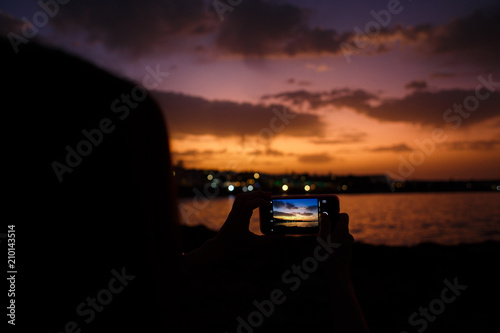  girl takes pictures of a beautiful sunset © Евгения Трастандецка