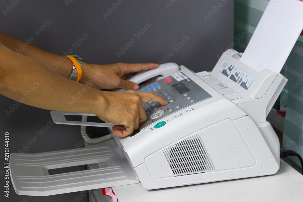 hand man are using a fax machine in the office. Business concept 