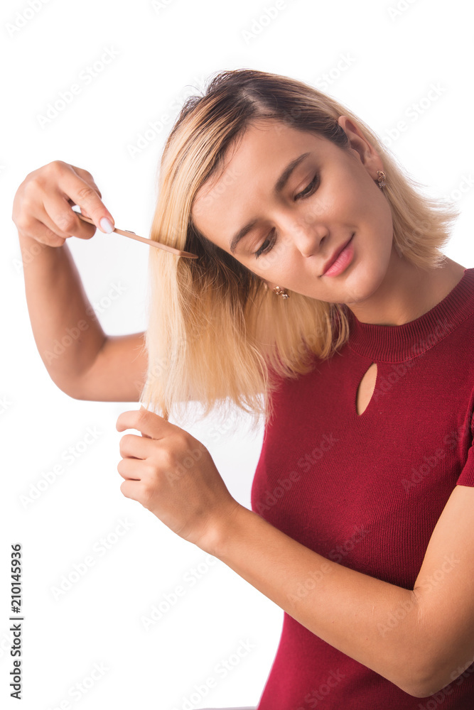Beautiful young woman combing her hair. Isolated on white Beautiful young woman combing her hair. Isolated on white