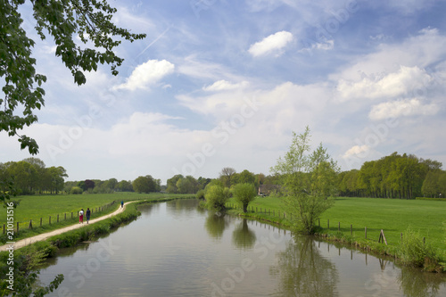 Authentic Dutch landscape with river Kromme Rijn, wanderers, walkway, clouds and trees photo