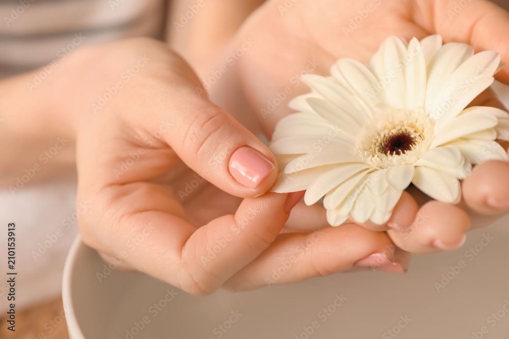 Young woman with fresh manicure and beautiful flower after treatment in spa salon, closeup Young woman with fresh manicure and beautiful flower after treatment in spa salon, closeup
