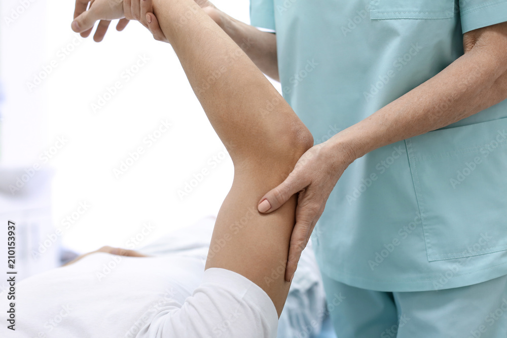 Orthopedist examining patient in hospital