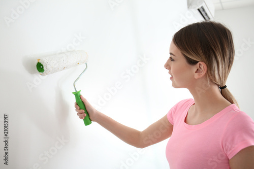 Female painter using roller...