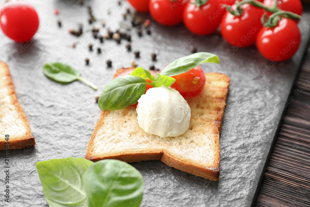 Toasted bread with cheese and tomatoes on slate plate Toasted bread with cheese and tomatoes on slate plate