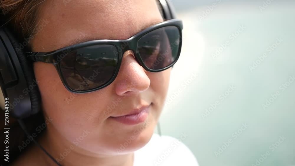 Young girl in sunglasses and headphones. close-up. slow motion, 1920x1080, full hd Young girl in sunglasses and headphones. close-up. slow motion, 1920x1080, full hd