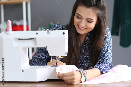 Young female tailor using s...