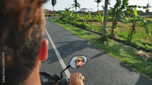 Man riding a motorcycle on the road, Indonesia, Bali.