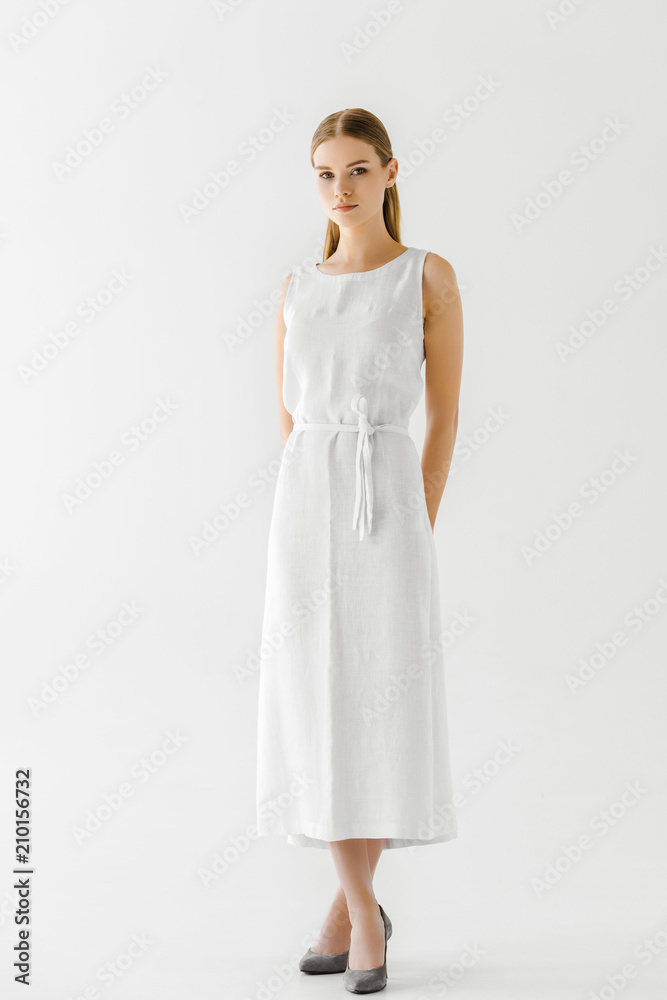 young attractive woman in linen white dress posing isolated on grey background young attractive woman in linen white dress posing isolated on grey background