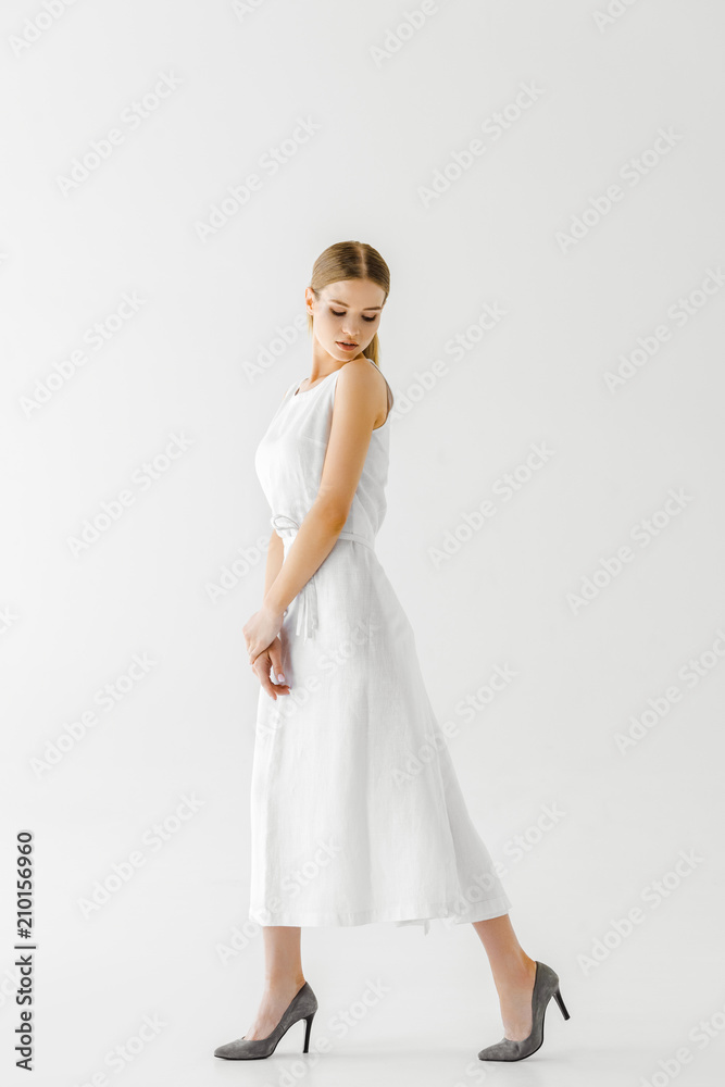 young female model in linen white dress posing isolated on grey background young female model in linen white dress posing isolated on grey background