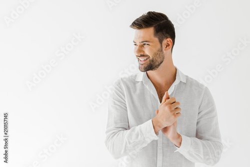 side view of smiling man in linen white shirt isolated on grey background photo