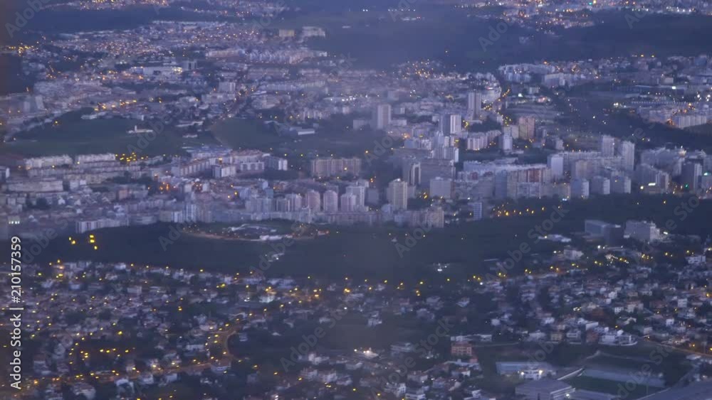 View from a landing airplane out the window of city at sunset View from a landing airplane out the window of city at sunset