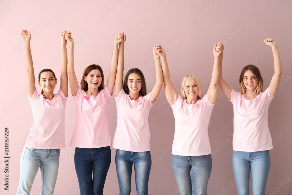 Fototapeta premium Beautiful women of different ages with pink ribbons on color background. Breast cancer concept