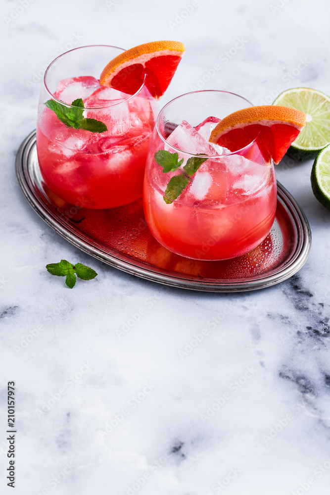 alcoholic cocktail Paloma of grapefruit and ice in glasses on a marble table . refreshing drink with lime juice alcoholic cocktail Paloma of grapefruit and ice in glasses on a marble table . refreshing drink with lime juice