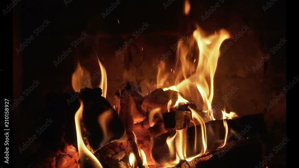 A fireplace with a hot roaring fire and red coals. Looping video. Slow motion A fireplace with a hot roaring fire and red coals. Looping video. Slow motion