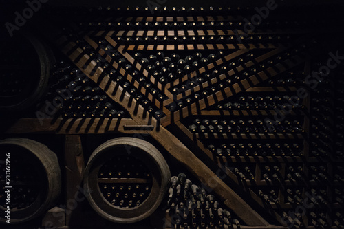 View of wine vault full of wine bottles on dark wooden shelves