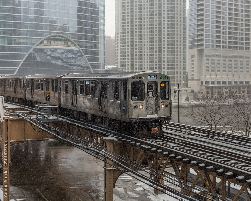 Naklejka premium Train entering city in snow