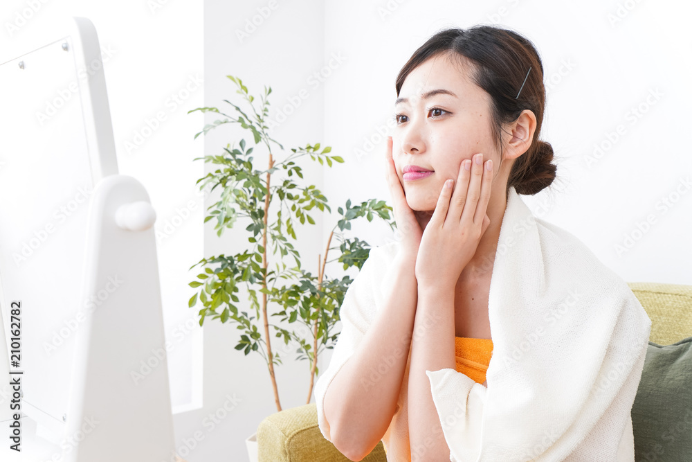 部屋でスキンケアをする若い女性 部屋でスキンケアをする若い女性