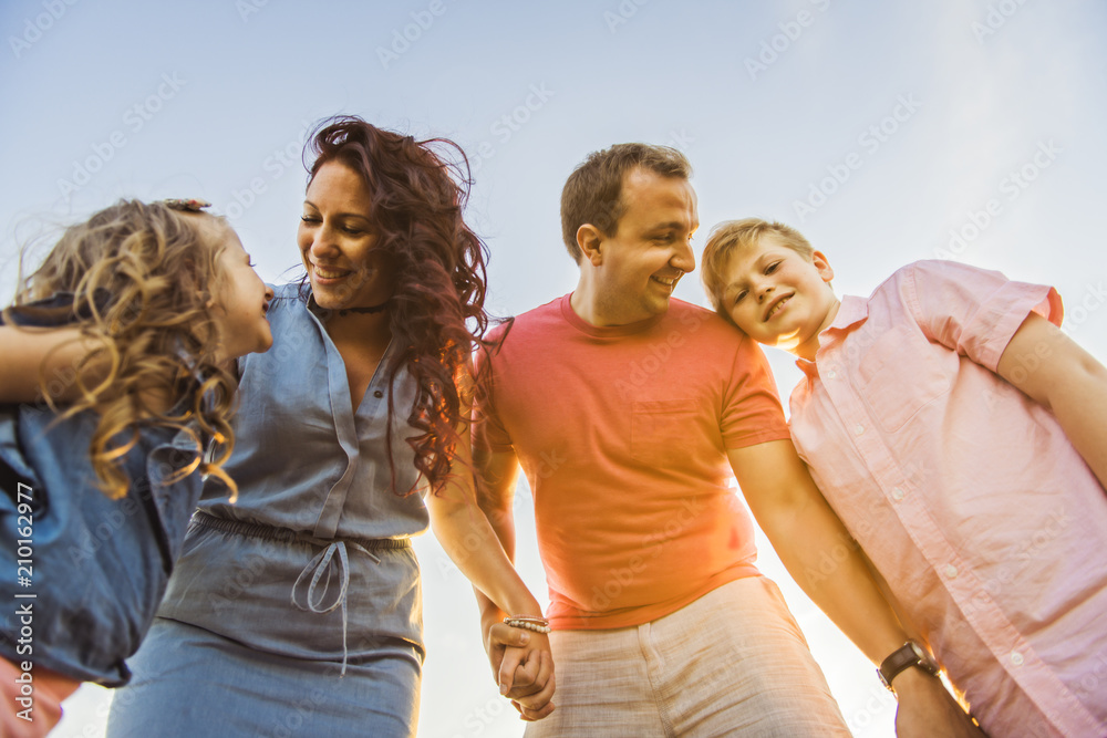 Happy family having fun on daisy field at sunset Happy family having fun on daisy field at sunset