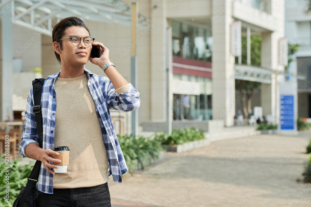 Young man with smartphone and coffee cup
