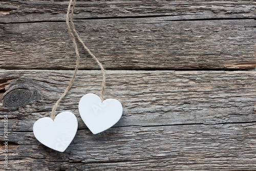 Two white hearts on rustic wooden background
