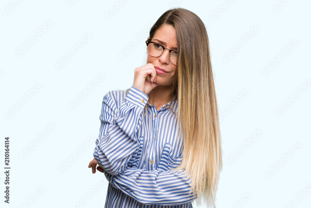 Beautiful young woman wearing elegant shirt and glasses looking stressed and nervous with hands on mouth biting nails. Anxiety problem. Beautiful young woman wearing elegant shirt and glasses looking stressed and nervous with hands on mouth biting nails. Anxiety problem.