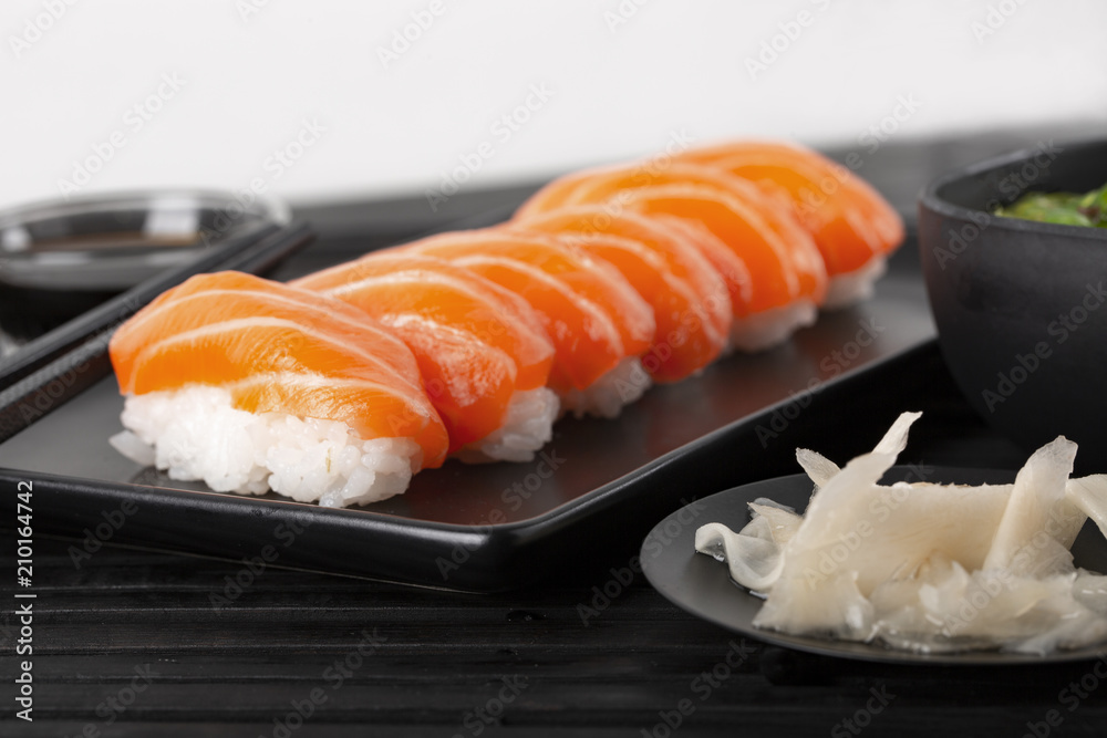 Sushi with salmon on a black plate. Ginger. Coricpace Sushi with salmon on a black plate. Ginger. Coricpace