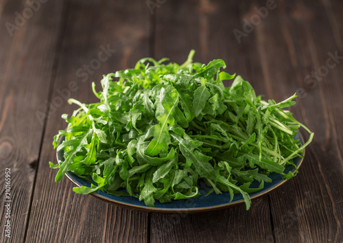 Fresh green arugula in bowl on table. Arugula rucola for salad. Close up of fresh green healthy food. Diet concept