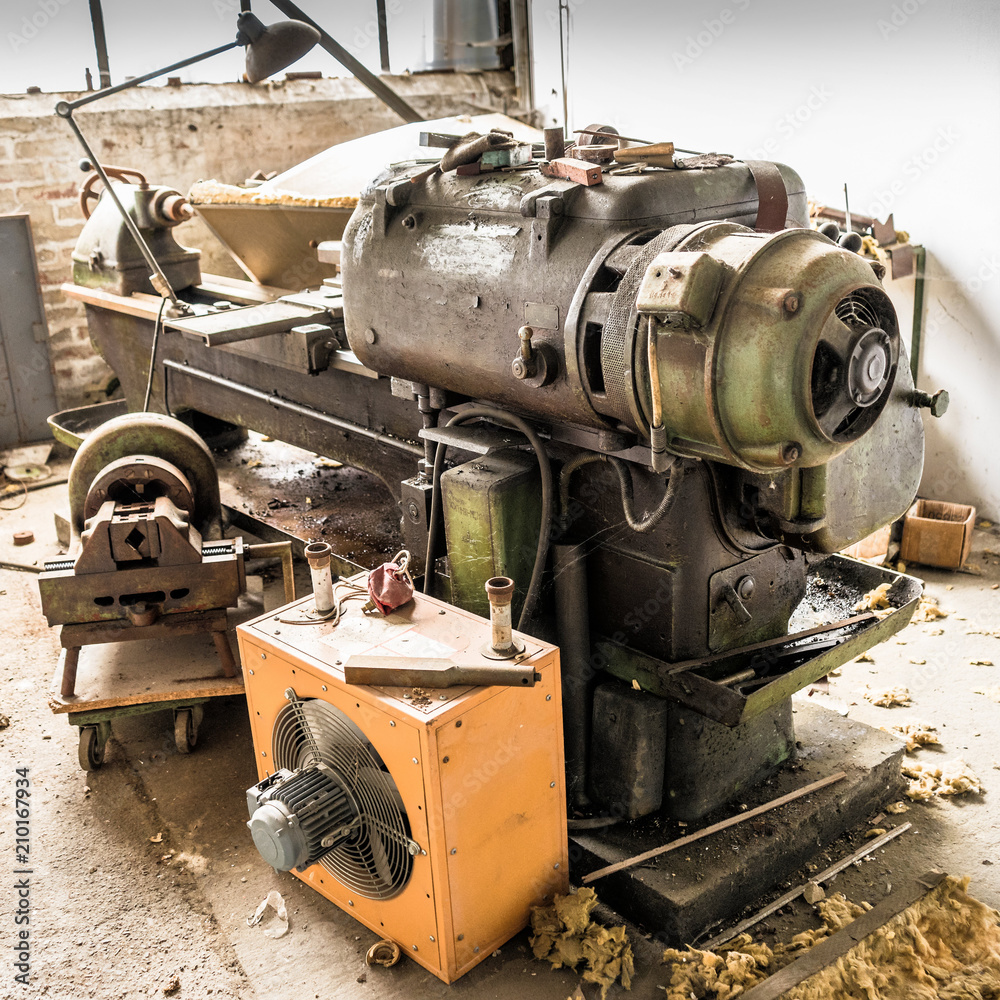Ancient rusted and oily lathe in an abandoned industrial hall