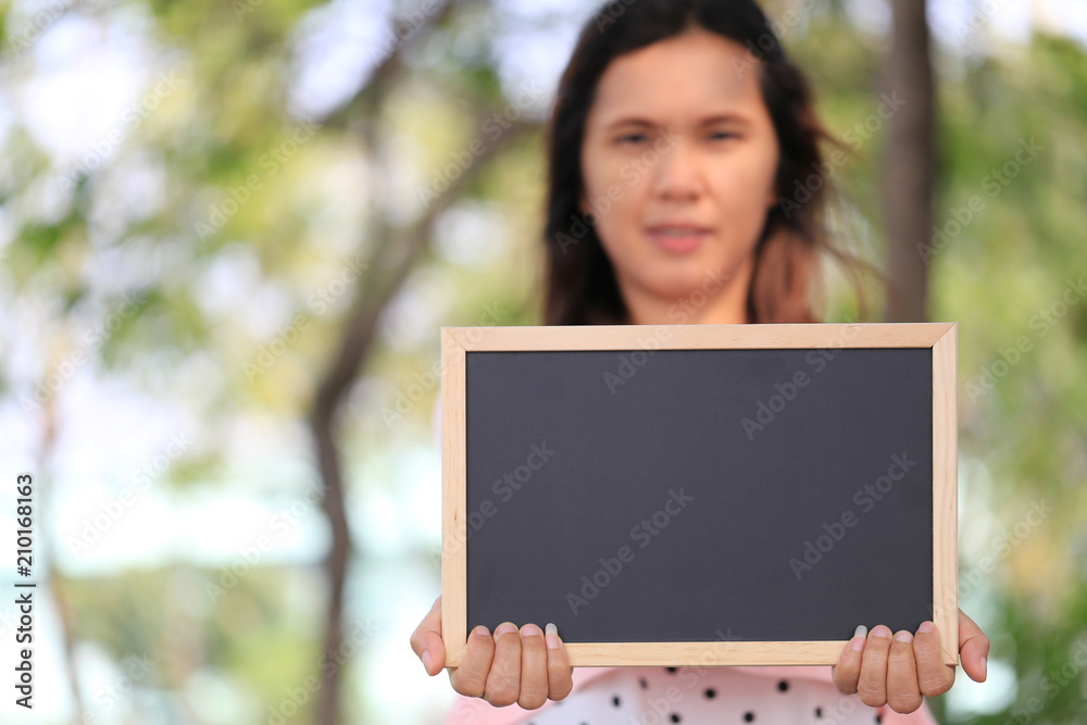 Fototapeta premium Asian women are pregnant for about twelve weeks to holding a blank blackboard.