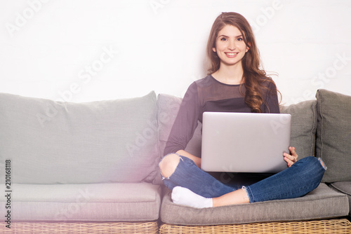 Junge Frau sympathisch lächelnd am Laptop 