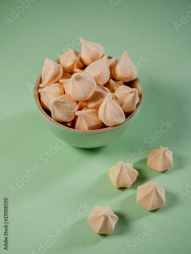 Colorful meringues in a mint green bowl