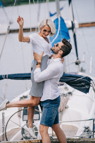 beautiful happy young couple having fun together on yacht