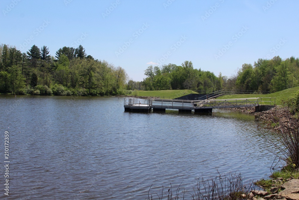 A side view of the fishing dock at the lake on a sunny day.