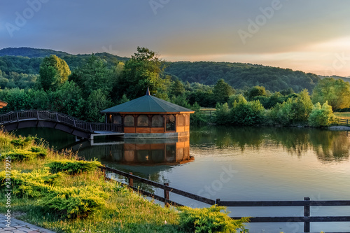 Beautiful landscape with nature and lake house illuminated in sunset light in Rasnov town, Romania