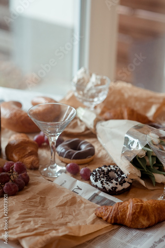 Still life, food and drink concept. Breakfast with croissants, fruits and champagne. Selective focus