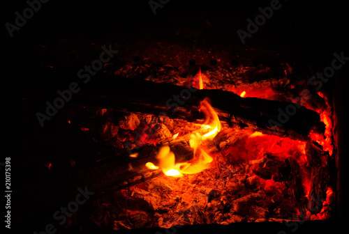 Burning and smoldering of the wood in the night time.