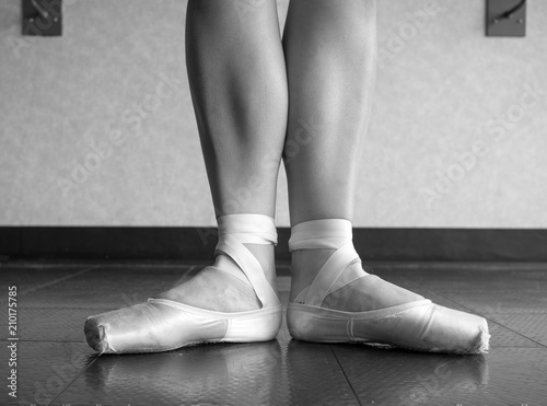 Black and white version of Ballerina in Ballet first position in ballet pointe shoes and bare legs 