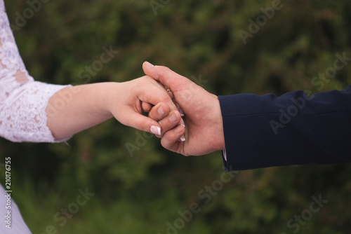 Bride and groom holding hands outdoors © mischenko