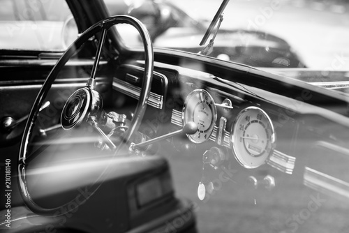Vintage retro car interior, steering wheel, dashboard, black and white photo