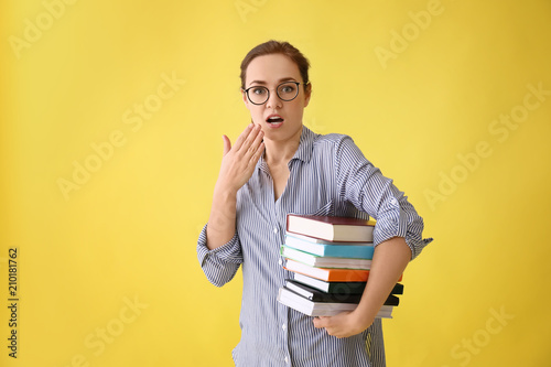 Young woman with stack of b...