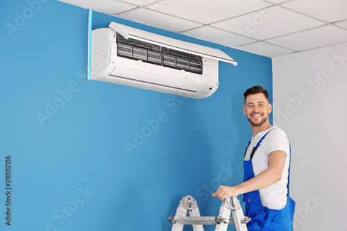 Electrician repairing air c...