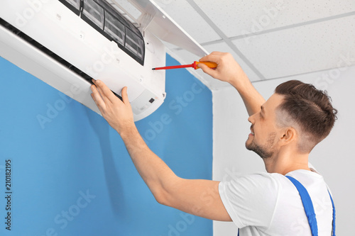 Electrician repairing air c...